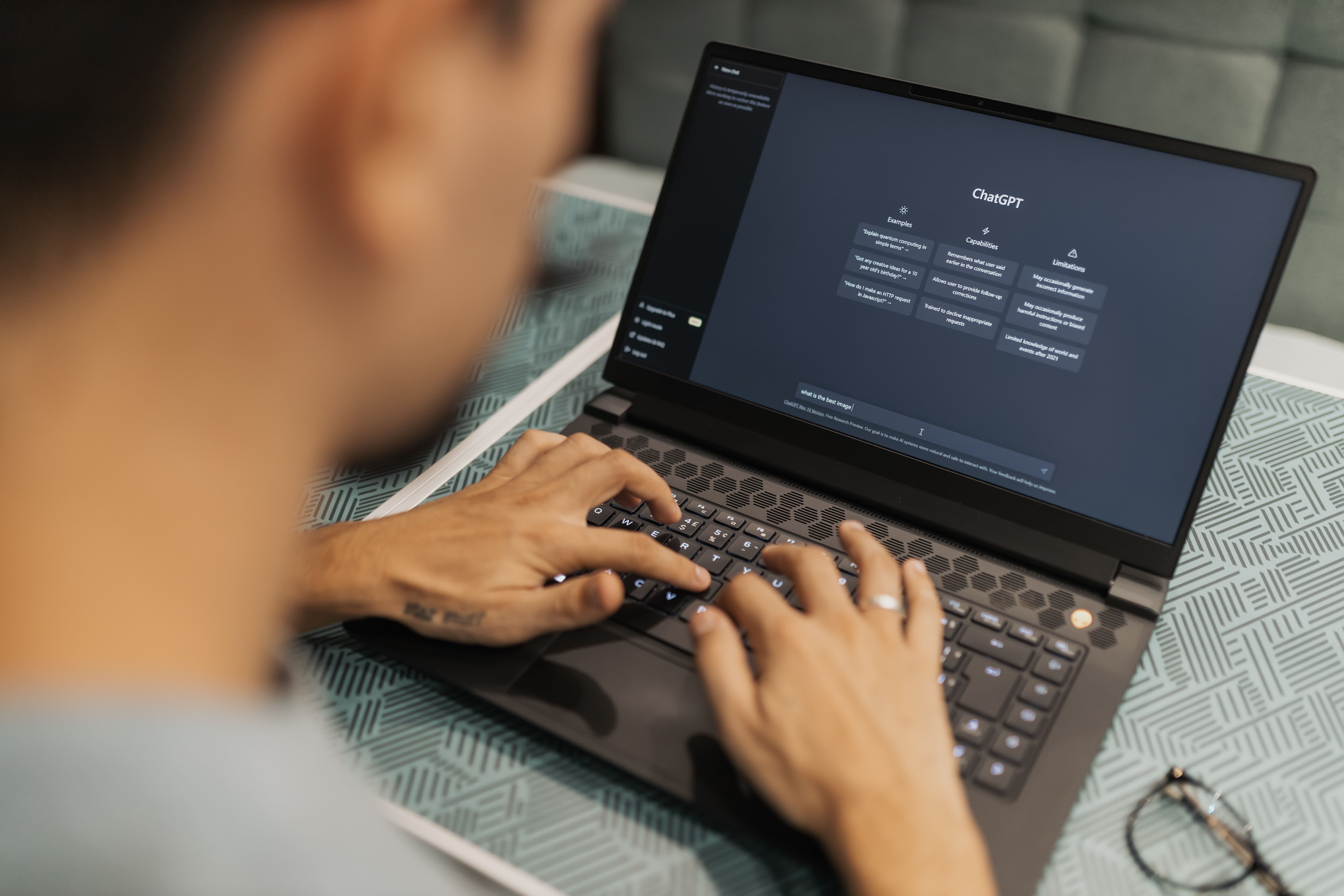 Person using AI software on a laptop in a focused workspace