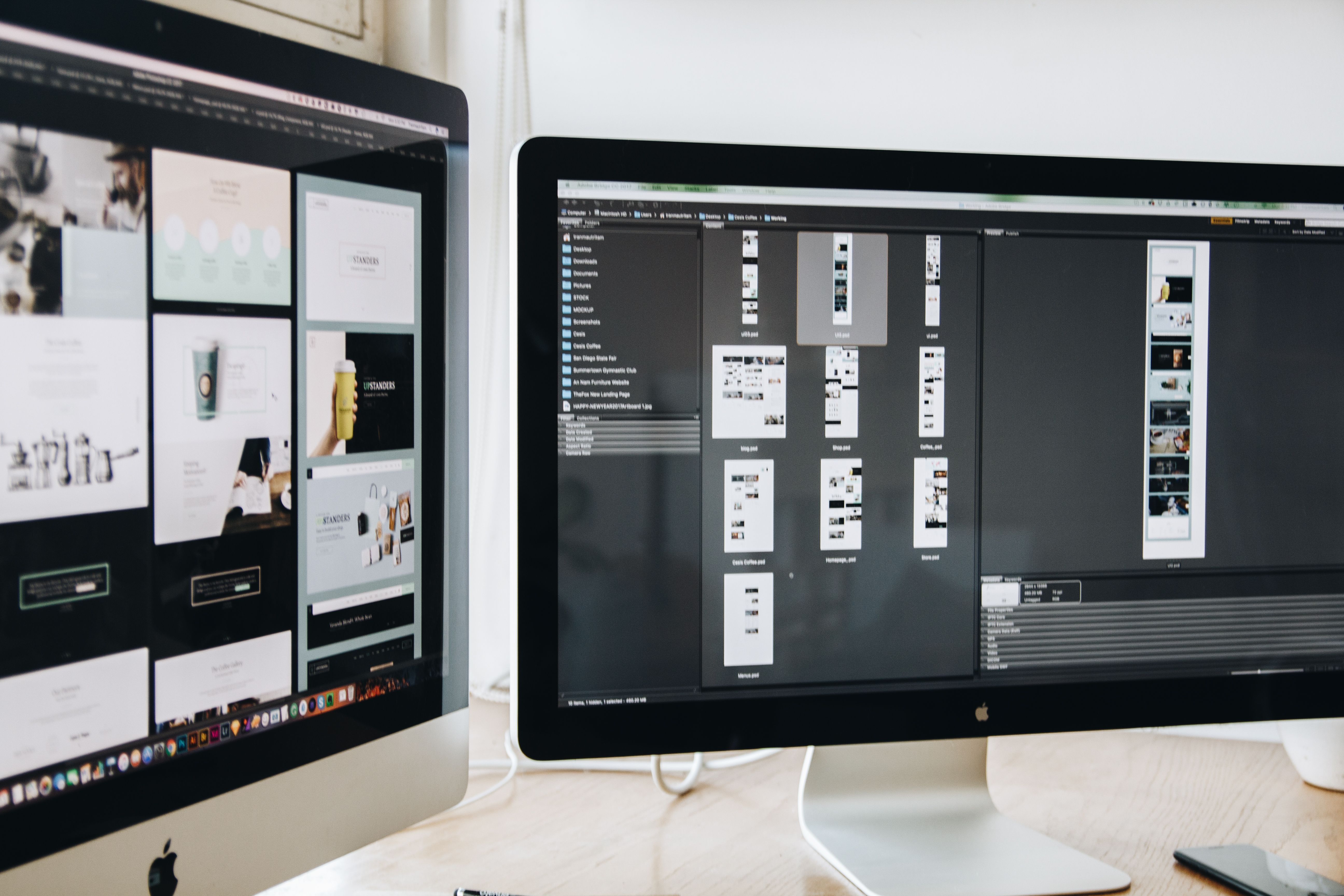 Dual monitors displaying web design projects, illustrating interface review across screens.